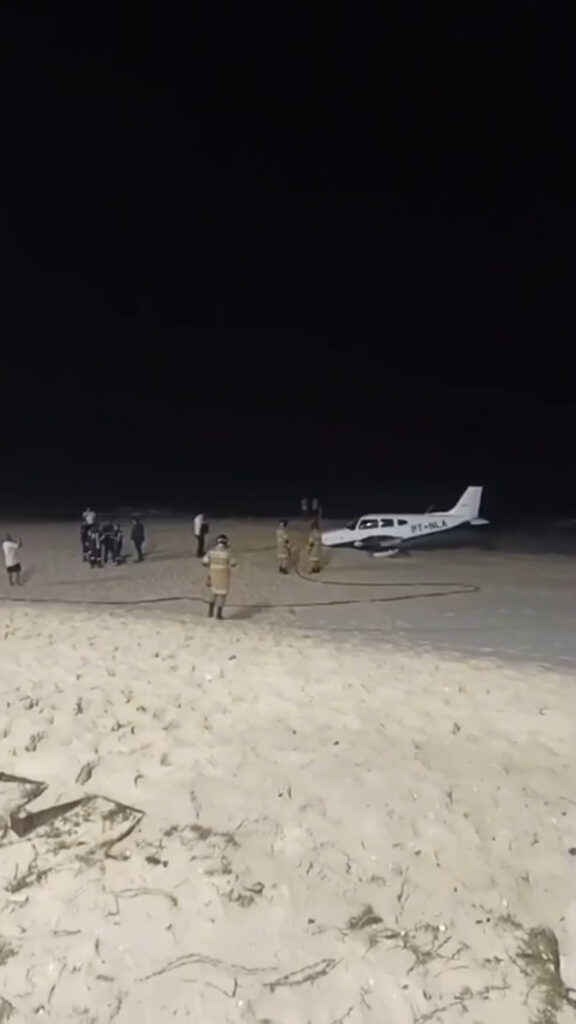 Foto reprodução de um vídeo mostra o avião parado na areia com bombeiros ao redor