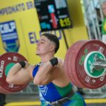 Foto mostra Matheus Pessanha levantando peso sobre os ombros