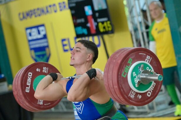 Foto mostra Matheus Pessanha levantando peso sobre os ombros