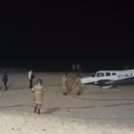 Foto reprodução de um vídeo mostra o avião parado na areia com bombeiros ao redor